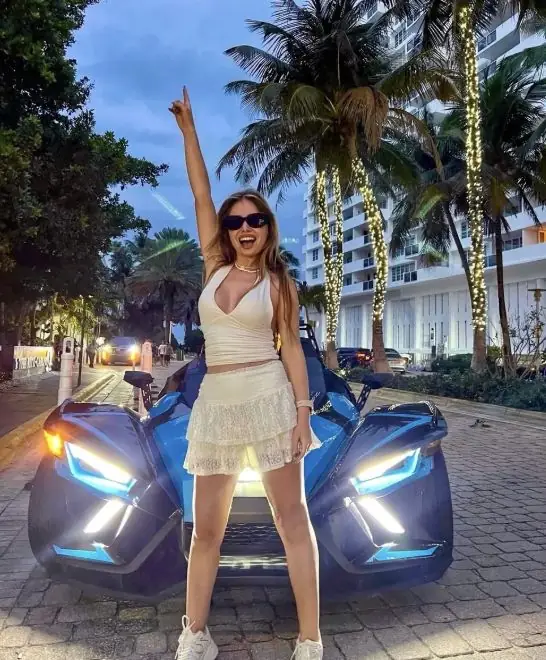 Black Polaris Slingshot rental Miami — couple enjoying the ride
